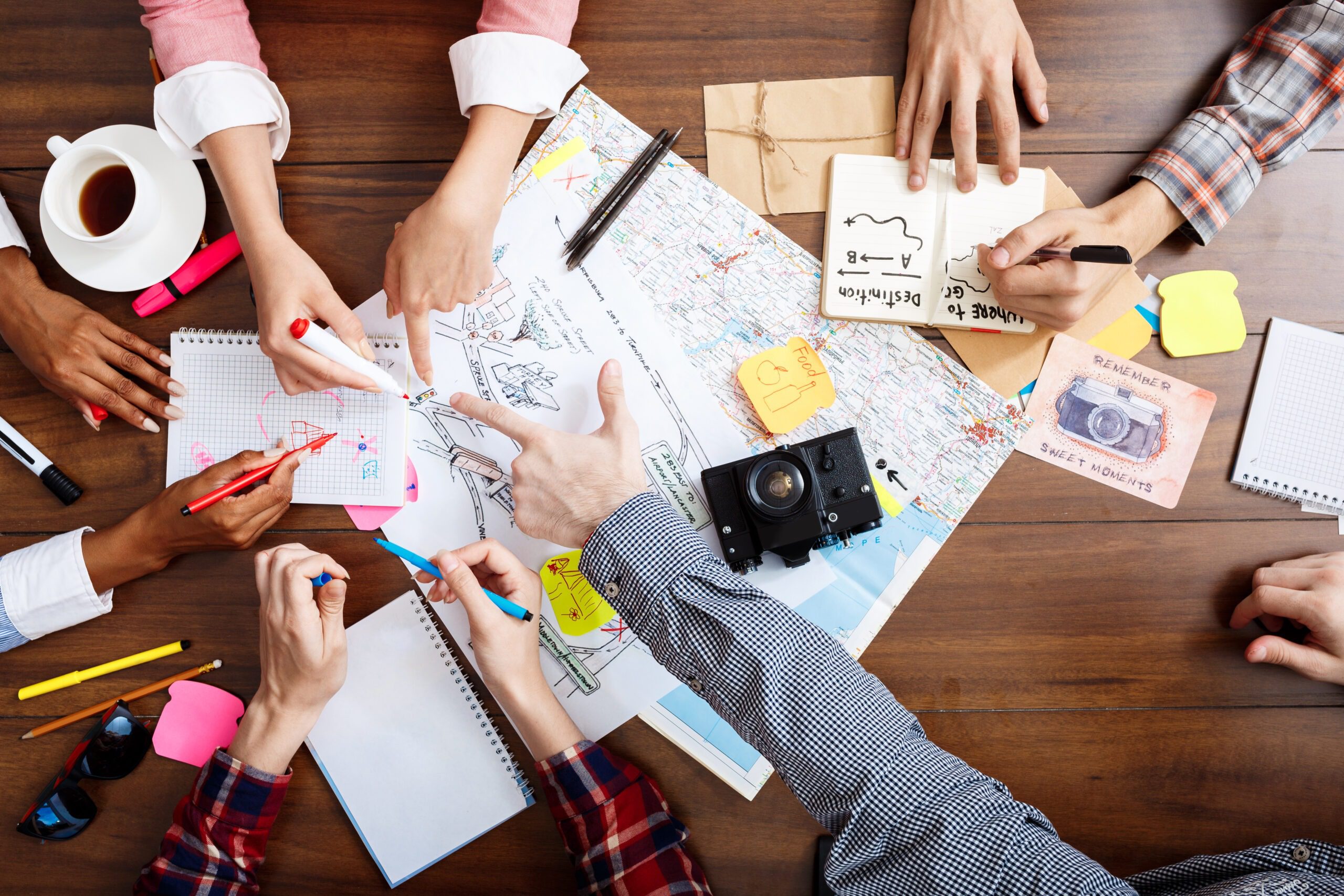 Picture of businessmen’s hands on wooden table with documents and drafts